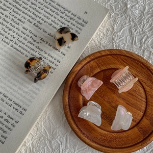 Set of 6 mini acetate hair claws in tortoise shell and marble patterns on a vintage tray