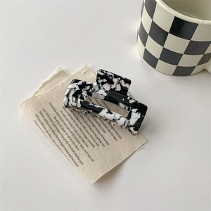 Détail d'une pince à cheveux rectangulaire à motif vache en matériau acrylique de qualité
