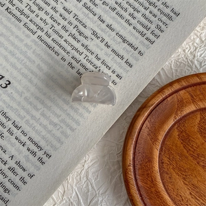 Detailed macro view of a grey marble pattern mini acetate hair claw on an open book