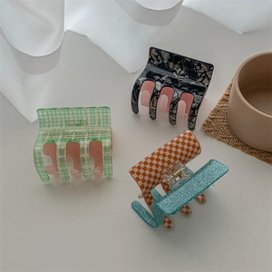 Three acetate hair claws with pink green checkers, marble texture, and glitter accents