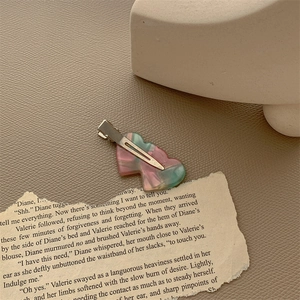 Detail of heart-shaped marble resin hair clip with silver metal duckbill clamp back