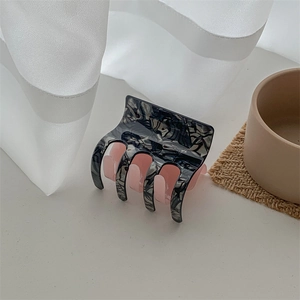 Detailed side view of checkered acetate hair claw clip with marble and pink tones