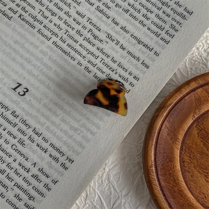 Close-up of tortoise shell mini hair claw clip placed on a vintage book page