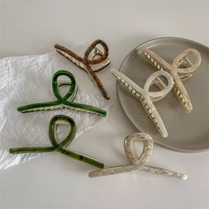 Set de cinco elegantes pinzas para el cabello de acetato en varios colores en una bandeja