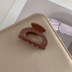 Dettaglio macro della pinza per capelli in acetato cioccolato con incisione a mano