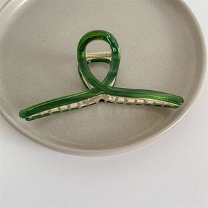 Detalle de la pinza para el pelo en acetato verde esmeralda con muelle metálico en cerámica