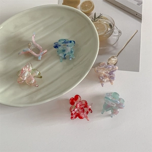 Floral acetate hair claws with marble texture in multiple vibrant colors shown on a plate