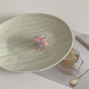 Close-up of a mini floral acetate hair claw clip on a stylish ceramic tray with Paris decor