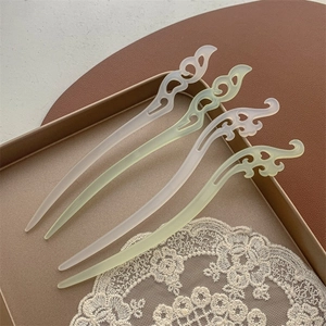 Détail de quatre épingles à cheveux chinoises avec motifs de nuages dans un plateau