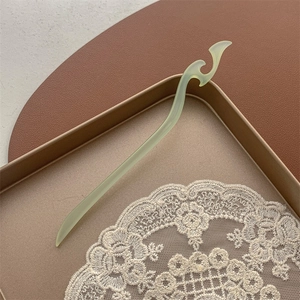 Détail d'une épingle à cheveux translucide vert pâle avec des motifs de nuages traditionnels