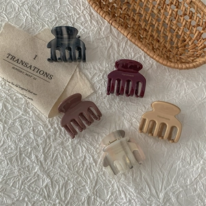 Five assorted acetate hair claws in marble and solid colors for elegant hairstyles