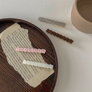 Set di quattro fermagli geometrici in acetato grigio, marrone, rosa e bianco con clip oro