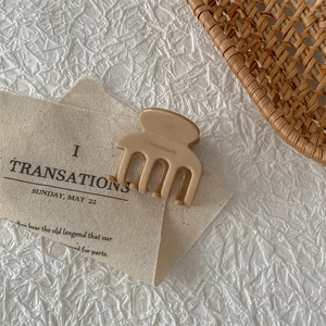 Detail of light brown acetate hair claw clip with handmade engraving on canvas