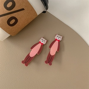 Dettaglio di due graziose mollette per capelli a forma di orso in marrone e rosa con fiocchi