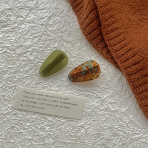Détail de deux barrettes gouttes en acétate vert olive et motif écaille de tortue