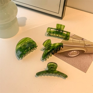 Set of four green translucent acetate hair claws in various elegant shapes with glossy finish
