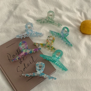 Set of large acetic acid hair claws with colorful marble patterns on white cloth background