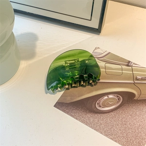 Macro shot of dark green translucent claw clip with a glossy finish and non-slip design
