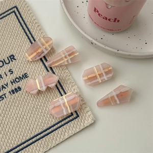 Set de 5 barrettes à cheveux roses en résine avec motif à carreaux sur lin beige doux
