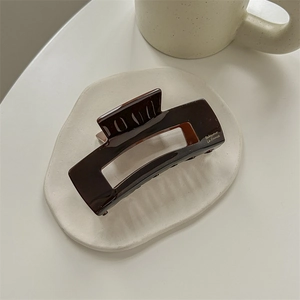 Detailed macro view of chocolate brown hair claw clip with Babyvovo La France text