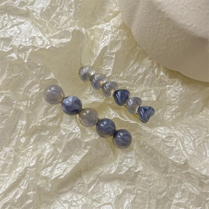 Détail de pinces à cheveux avec perles en acrylique marbré sur métal doré