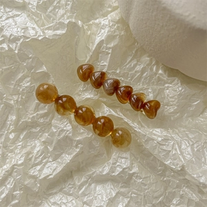 Détail de barrettes à cheveux ambre avec perles rondes et cœurs sur papier artistique