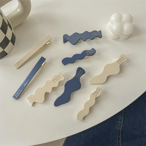 8-piece blue and beige minimalist hair clip set with resin finish on a white background