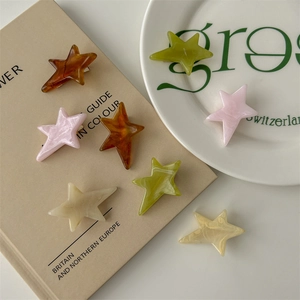 Star-shaped acetate hair clips in marble brown and pastel colors on aesthetic background