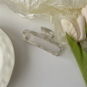 Detailed macro view of an elegant acetate hair claw with grey-purple marble texture