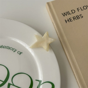 Close-up of star-shaped cream acetate hair clip with marble texture on decor tray