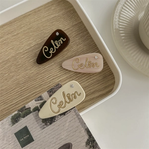 Three elegant French hair clips with Celin lettering in tortoise and marble patterns