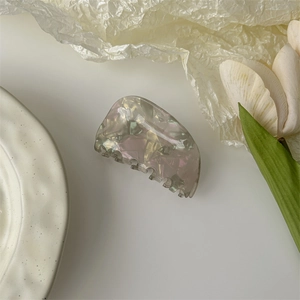 Detail of a mosaic shell texture hair claw clip with elegant iridescent resin finish