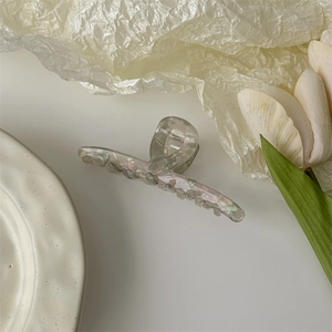 Detailed view of large marble texture acetate hair claw clip with pearlescent finish