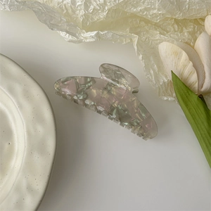Detail of large acetate hair claw clip with colorful floral marble texture for women
