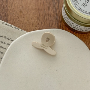 Nahaufnahme der beigefarbenen Mini-Haarklammer mit France Handmade-Aufdruck auf Teller