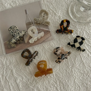 Detailed top view of cellulose acetate hair claws in various patterns on white fabric