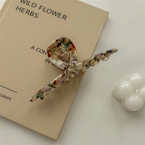 Detail of large acetate hair claw clip with colorful stone pattern and Handmade text