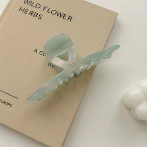Detail of light green acetate hair claw clip with France Handmade silver engraving