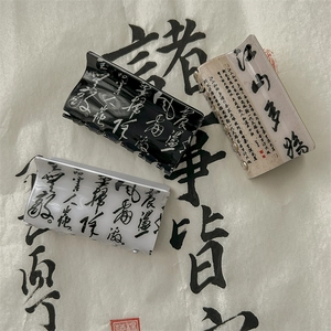Three-piece Chinese calligraphy claw clip set in black, white, and translucent apricot