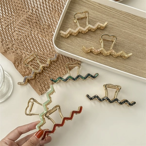 Set of six elegant wave-shaped metal hair claws with heart handles and marble textures