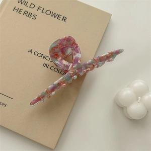 Detail of large marble texture acetate hair claw clip on a vintage book
