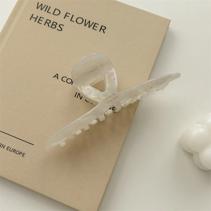 Detail view of large cream-white acetic acid hair claw with France Handmade lettering