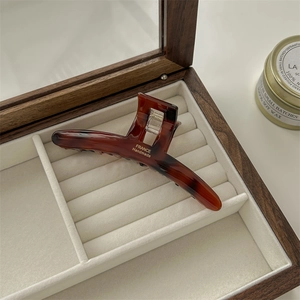 Detail of tortoiseshell hair claw with gold France Handmade logo in a velvet jewelry box