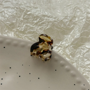 Gros plan d'une mini pince à cheveux en écaille de tortue faite main sur une assiette