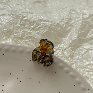 Détail d'une mini pince à cheveux en acétate écaille de tortue sur un plateau en céramique