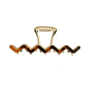 Elegant wavy metal claw clip with tortoise shell pattern on minimalist white background
