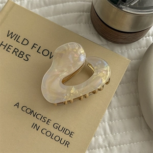 Close-up of irregular heart cellulose acetate hair claw clip with pearlescent finish