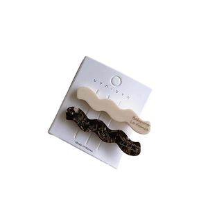 Set of two vintage wavy acetate hair clips in creamy white and tortoiseshell marble patterns