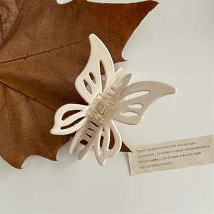Close-up of a cream butterfly hair claw clip with detailed spring and autumn aesthetic