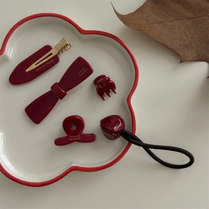 Deep red acetate hair clip set featuring shark clips and hair ties in cloud tray